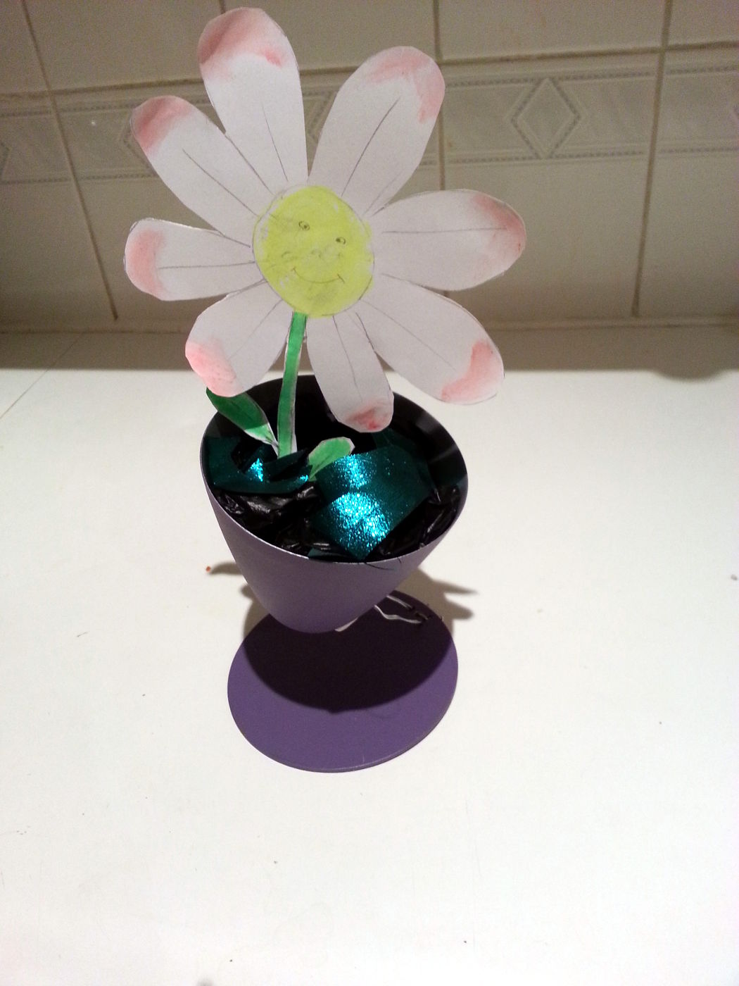 Happy little flower in a lamp-made plant pot